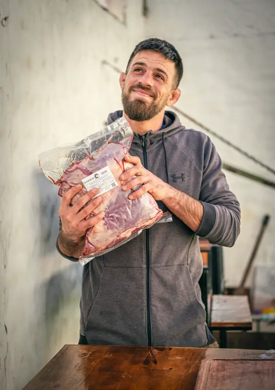El carnicero de Tu Corte Ya sonriendo, abraza un vacío envasado