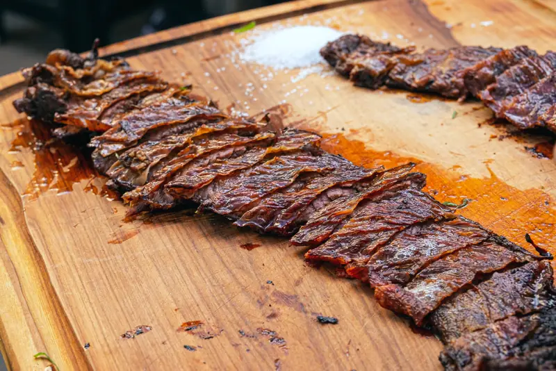 Entraña a la parrilla feteada sobre la tabla, con sal gruesa